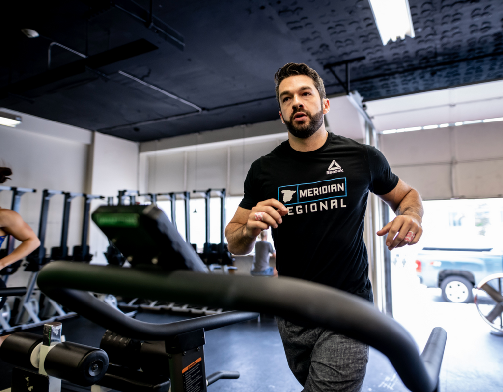 Close up of a person running on the Assaultrunner inside a gym among other fitness equipment